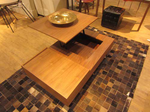 Walnut wood coffee table that has a hinge to allow the top to swivel upward to form a higher table. Transforming furniture.