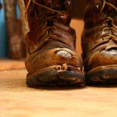 well worn steel toed boots with the steel showing through the toes.