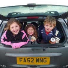 3-kids-in-the-back-of-car-looking-out