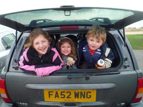 3-kids-in-the-back-of-car-looking-out