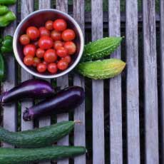 Old wood table with various vegetables, tomato, cumcumber, eggplant