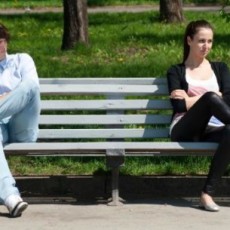 Breaking up. A couple distantly sitting on a bench while not talking.