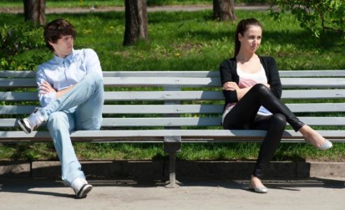 Breaking up. A couple distantly sitting on a bench while not talking.