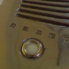 Closeup of reflective surface with reset button inset