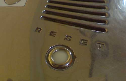 Closeup of reflective surface with reset button inset