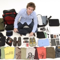 Colin Wright from Exile Lifestyle sits crosslegged, surrounded by the 55 items he travels the world with.