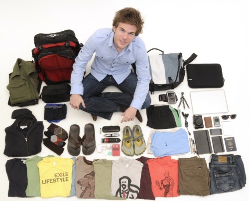 Colin Wright from Exile Lifestyle sits crosslegged, surrounded by the 55 items he travels the world with.