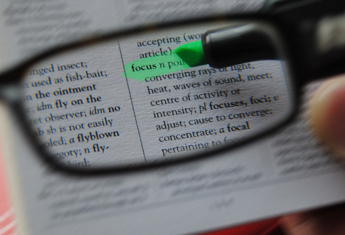 Minimalism is a focusing tool just like reading glasses; shown here highlighting the word "focus" in a book.