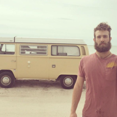 The simple life. Millionaire pitcher Daniel Norris holds a baseball out while standing on the beach in front of the VW van he lives in.