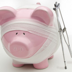 Injured piggy bank with crutches and bandages. Are your savings healthy? If not, consider less stuff more money.