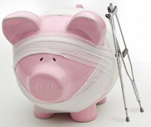 Injured piggy bank with crutches and bandages. Are your savings healthy? If not, consider less stuff more money.